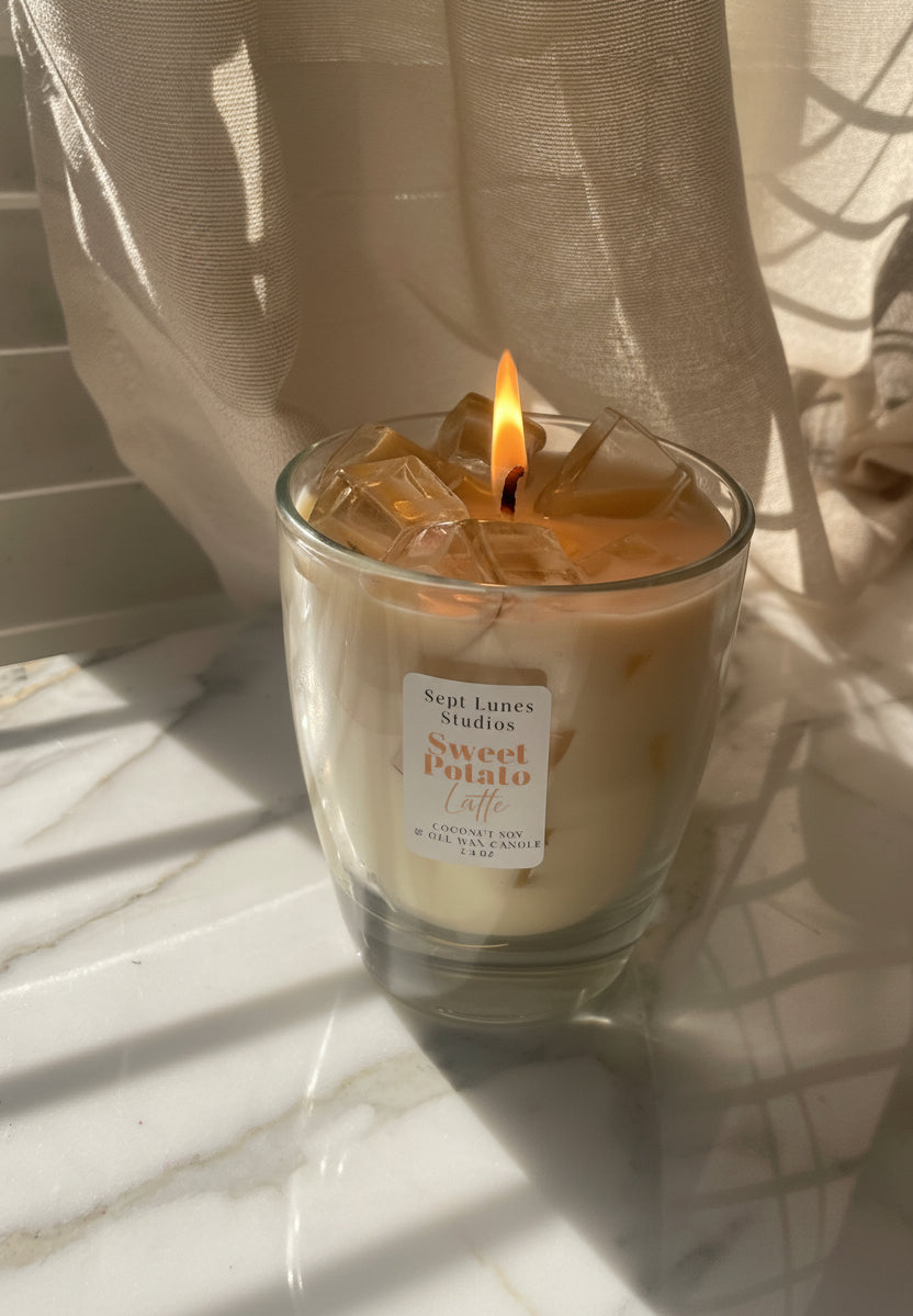 Iced coffee with a sweet potato flavor label on a marble surface with curtains in the background